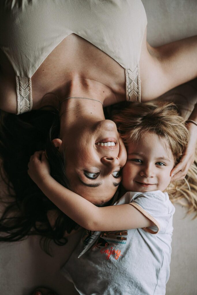 Une femme et une petite fille allongées sur le sol, capturant l'instant comme pour lui apprendre à commenter et devenir photographe.