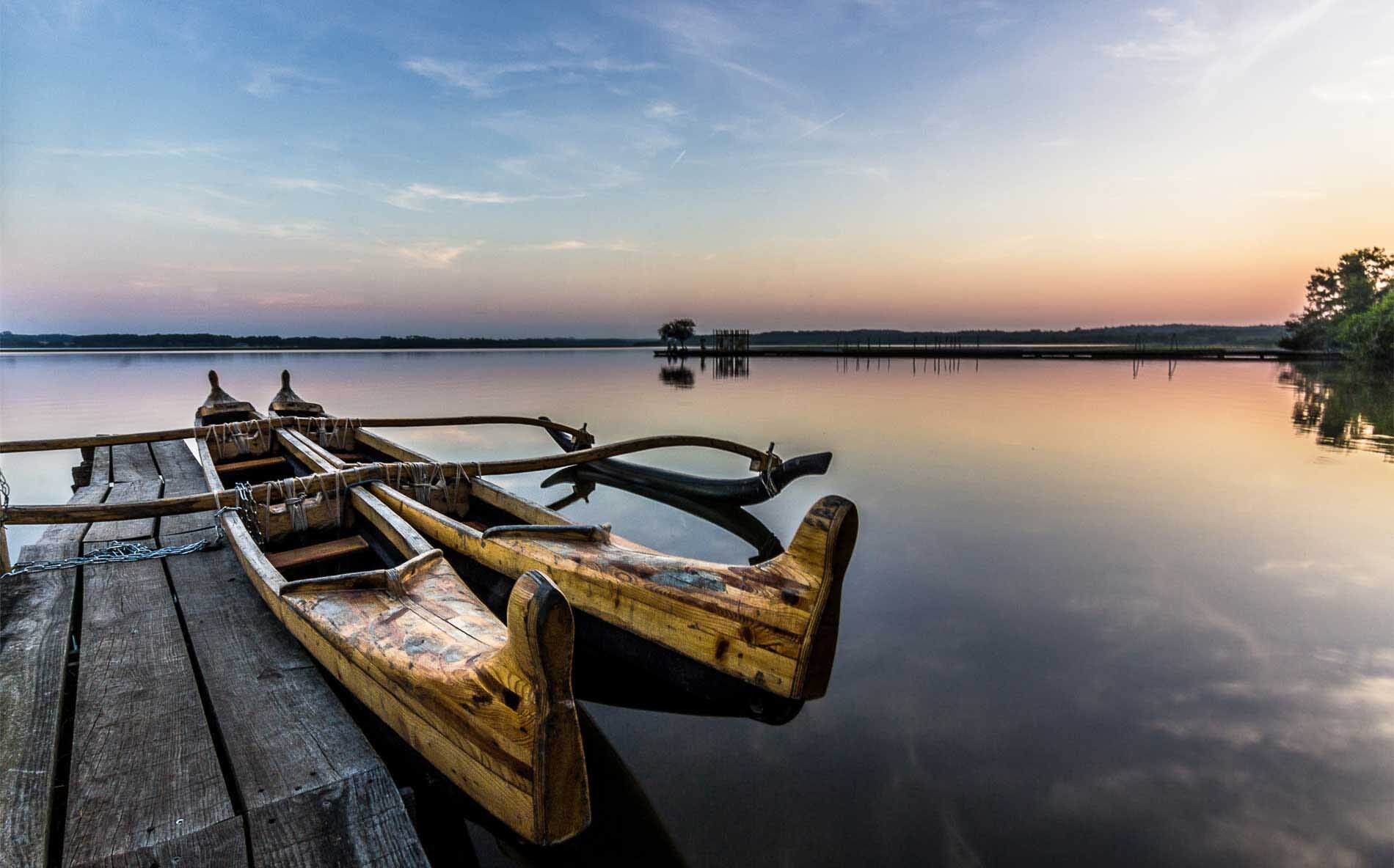 Deux canots posés sur un quai au coucher du soleil, une scène parfaite pour commenter devenir photographe.