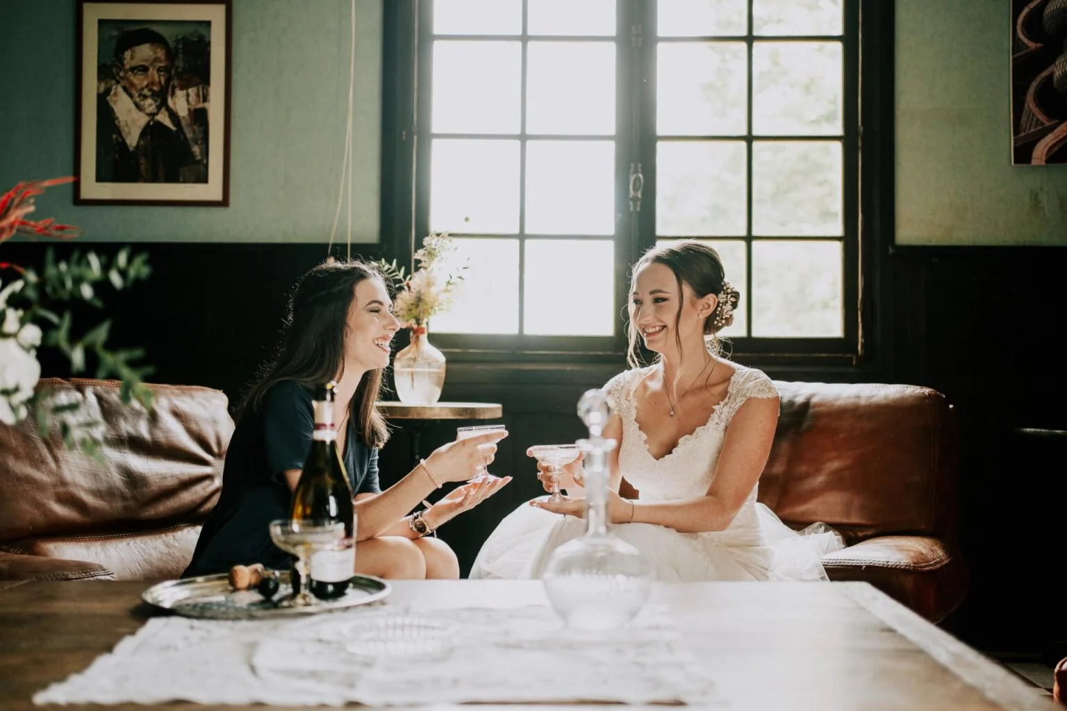Deux mariées assises à une table, buvant du vin, photographiées par le photographe mariage Landes.
