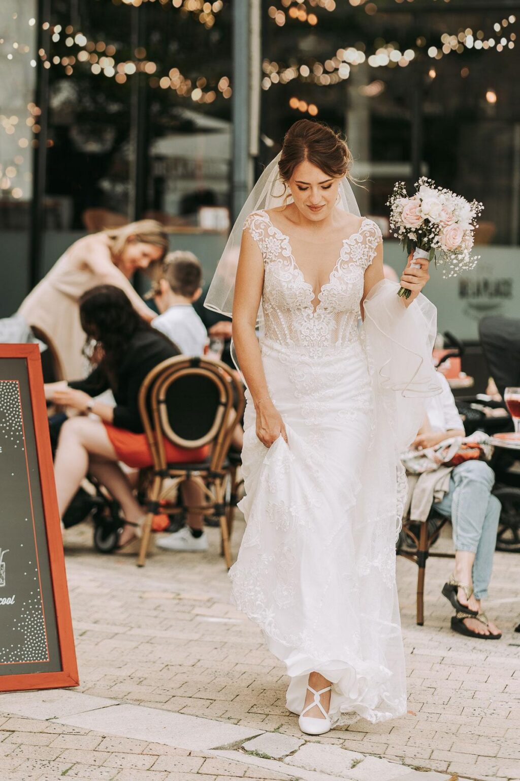 Une mariée marchant dans une rue avec une pancarte, capturée par un photographe mariage Biarritz.