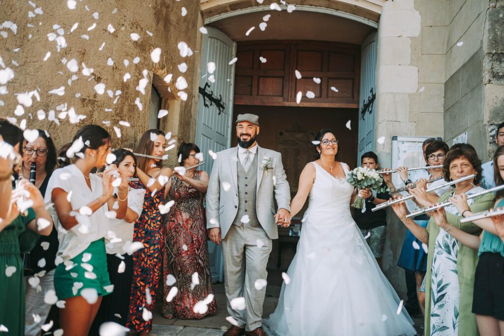 Les mariés sont entourés de confettis lancés sur eux lors d'un mariage landais.