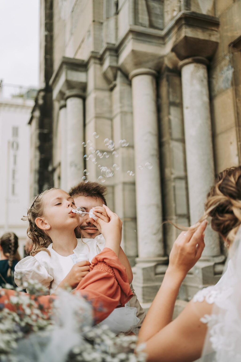 Des mariés faisant des bulles devant une église, photographiés par un photographe mariage Biarritz.