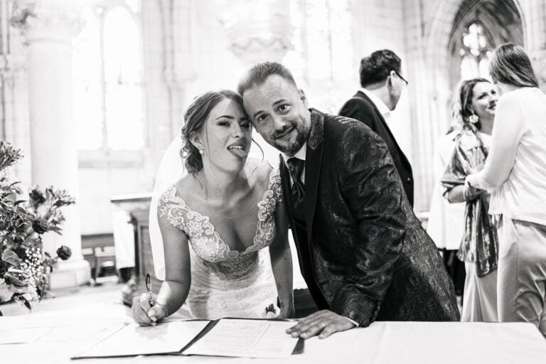 Des mariés signant leurs vœux de mariage dans une église, capturés par un "photographe mariage Biarritz".