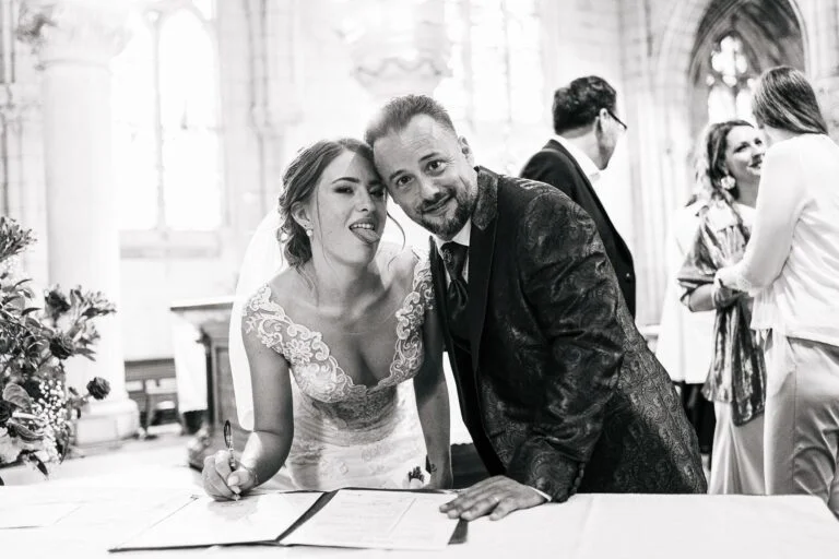 Des mariés signant leurs vœux de mariage dans une église, capturés par un "photographe mariage Biarritz".