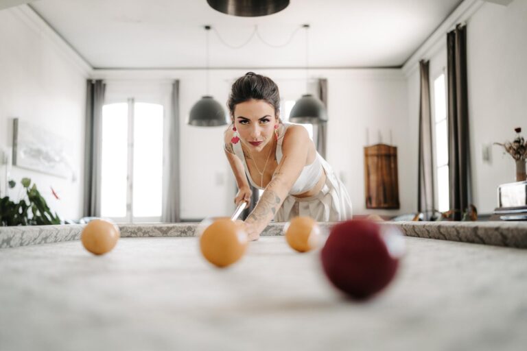 Une femme jouant au billard dans un salon magenta.