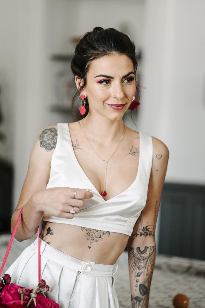 Une femme tatouée tenant un sac magenta.