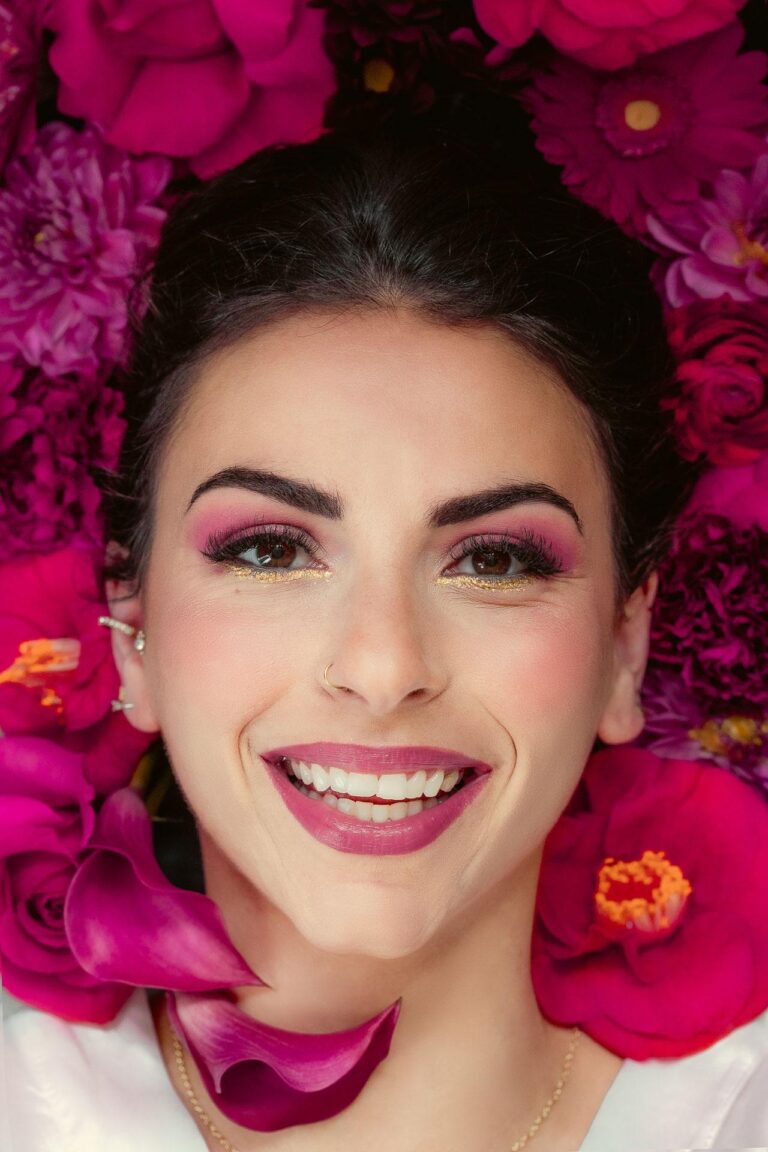 Une femme, trouvant l'inspiration pour son mariage, est entourée de fleurs magenta.
