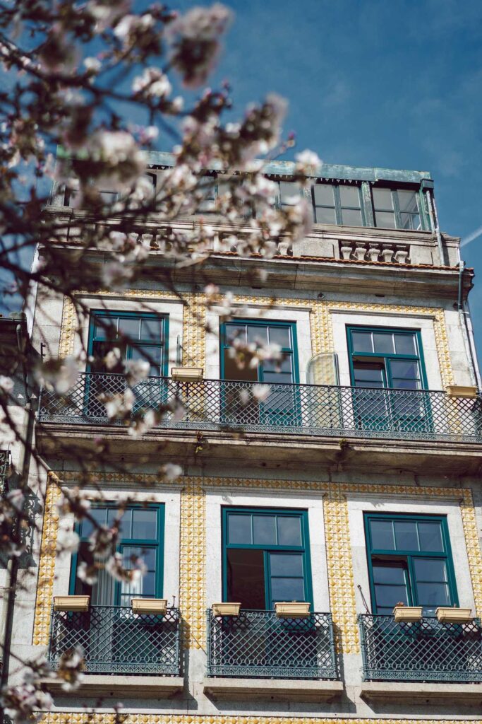 Un immeuble avec balcons et fleurs, parfait pour des vacances à Porto.