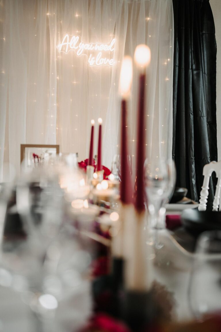 Une table dressée avec des bougies et des fleurs magenta pour vous inspirer.