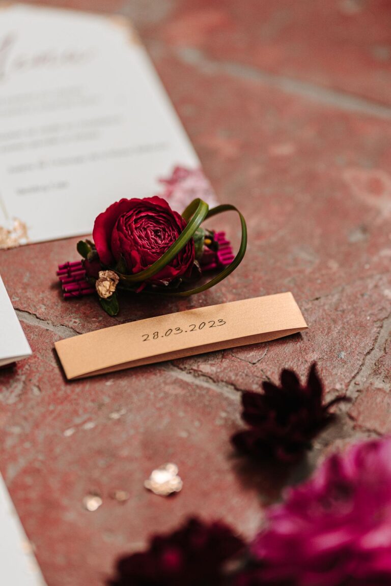 Papeterie de mariage bordeaux et magenta et fleurs sur une table comme source d'inspiration.