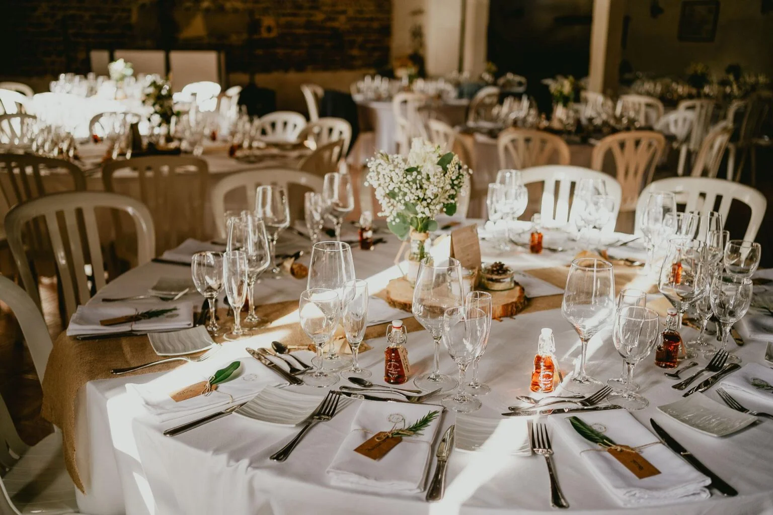Une table dressée pour un mariage dans une grange.