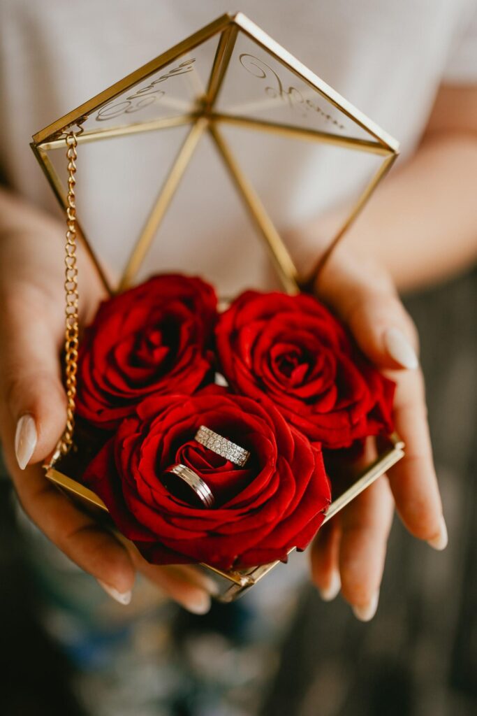 Une personne tenant une boîte contenant des roses rouges capte l'attention de tous, "comment trouver son photographe mariage", se demandent-ils, témoins de ce beau moment digne d'être immortalisé.
