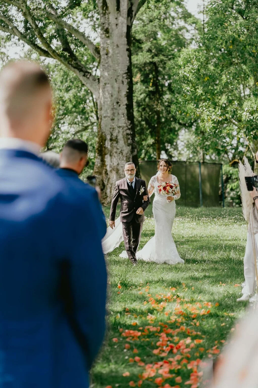 Des mariés marchant dans l'allée lors d'un mariage en plein air Castex d'Armagnac.