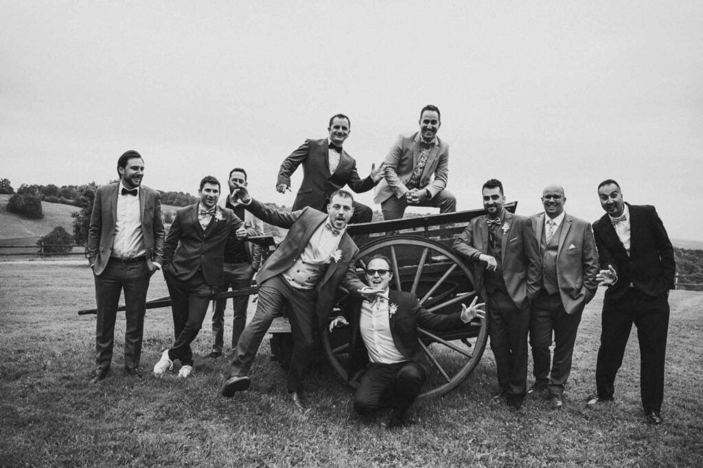 Une photo en noir et blanc d’un groupe d’hommes posant devant un canon lors d’un mariage hippie.