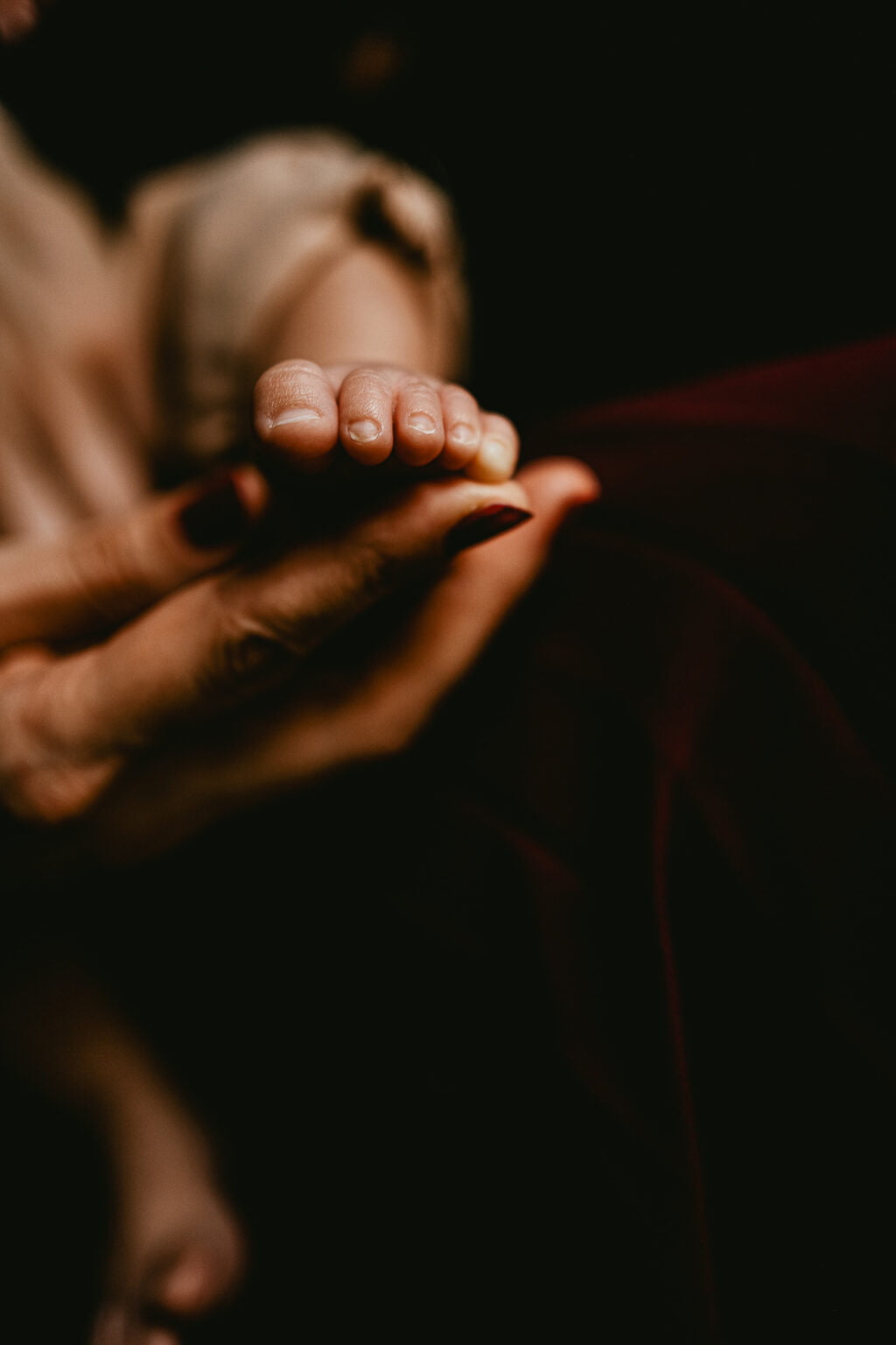 La main d'une femme tenant le pied d'un bébé.