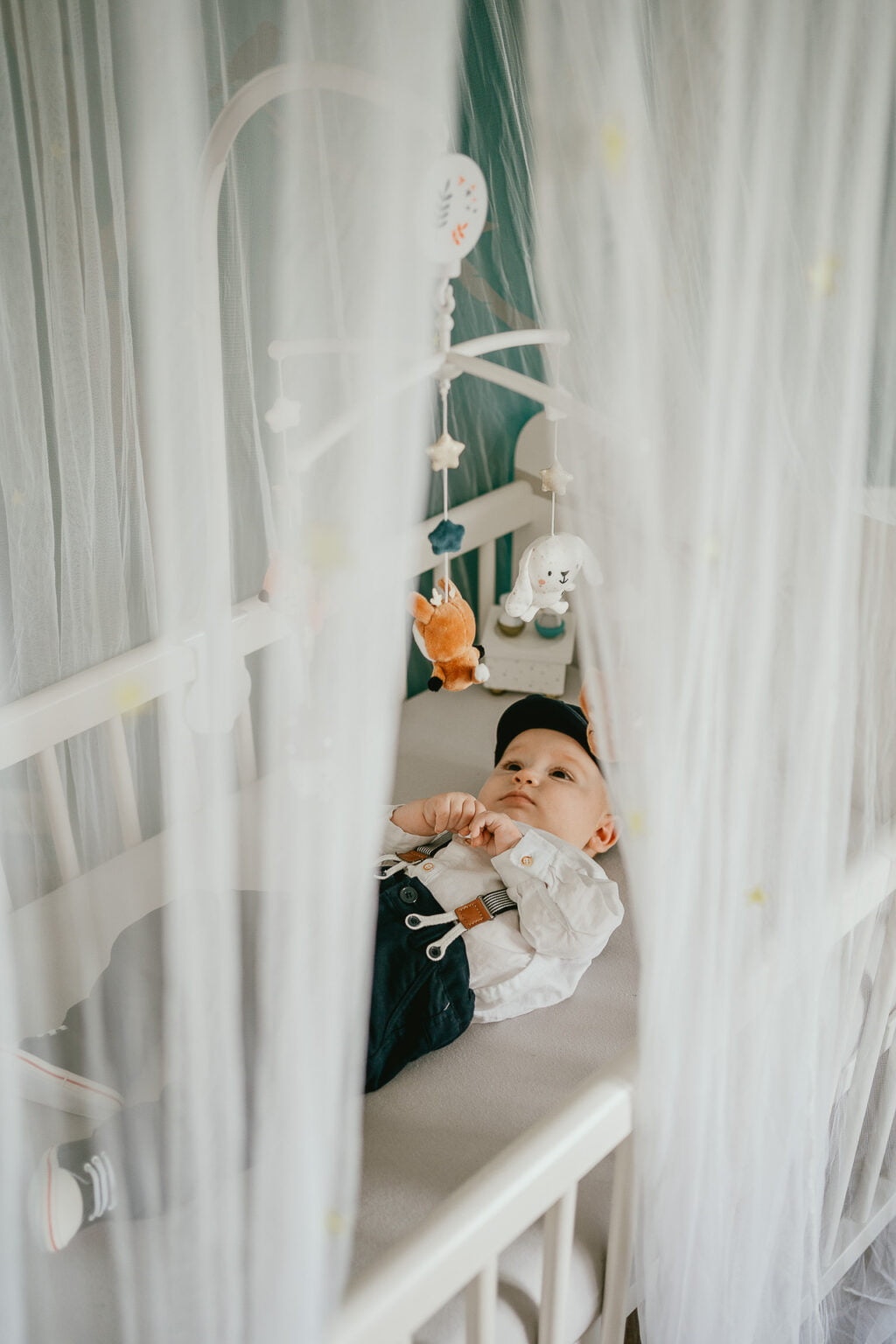 Un bébé allongé dans un berceau avec une moustiquaire.