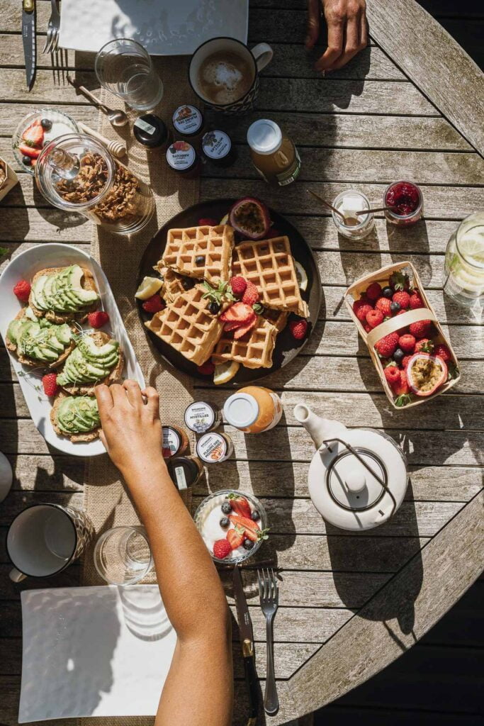 Un groupe de personnes prenant leur petit-déjeuner sur une table en bois.