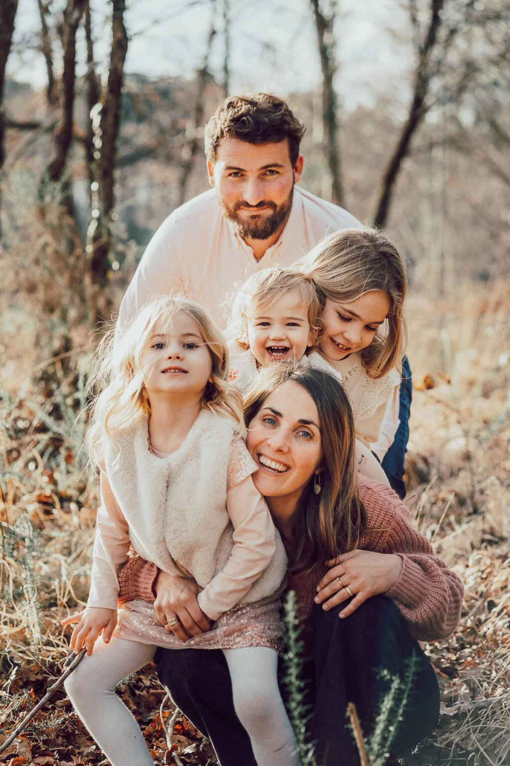 Famille réunie dans un champ landais, rires partagés au coucher du soleil.