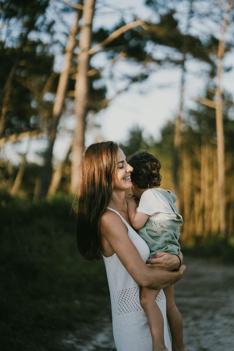 Une femme tient son fils dans les bois pendant une séance photo.