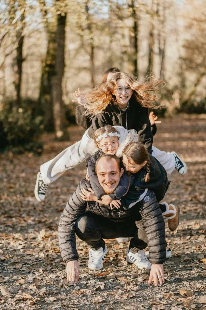 Une famille s'amusant lors d'une séance photo dans les bois.