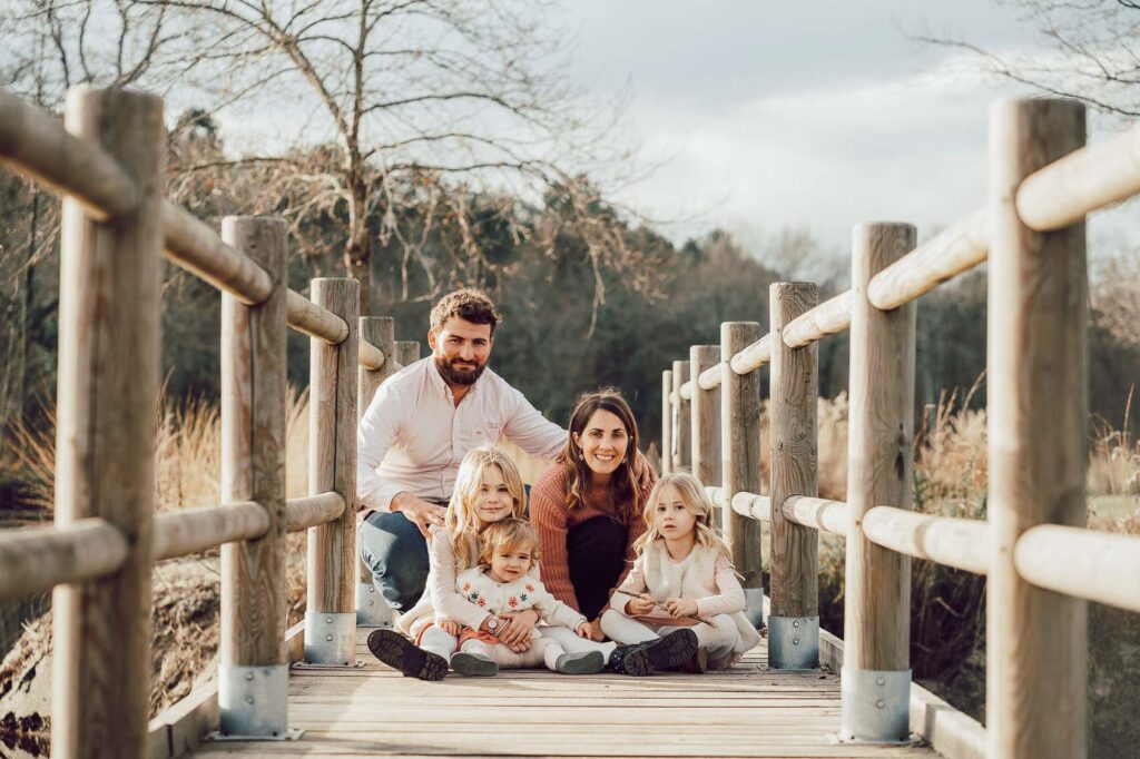 Une famille pose sur un pont de bois pour une séance photo dans les Landes.