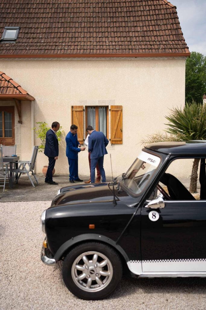 Une mini Cooper noire garée devant une maison pour un mariage hippie.