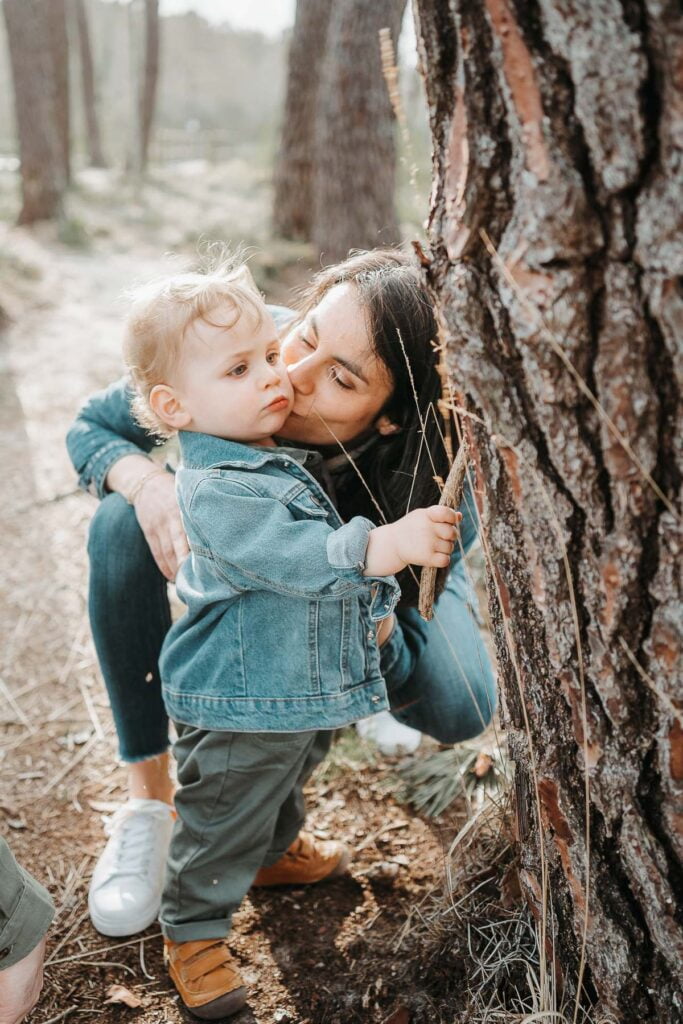 Une femme embrasse son fils dans les bois.