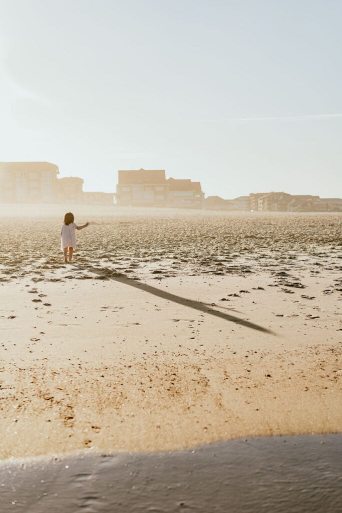 Un enfant fait voler un cerf-volant sur la plage.