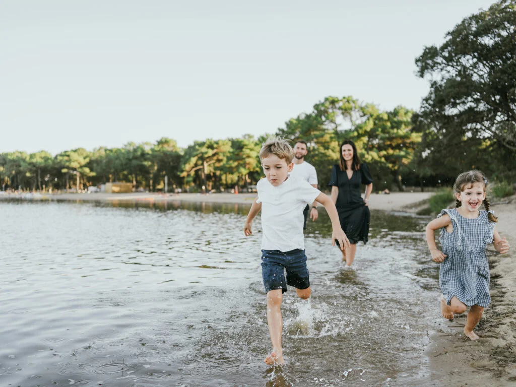 une famille court au bord de l'eau au lac de Soustons dans les Landes.