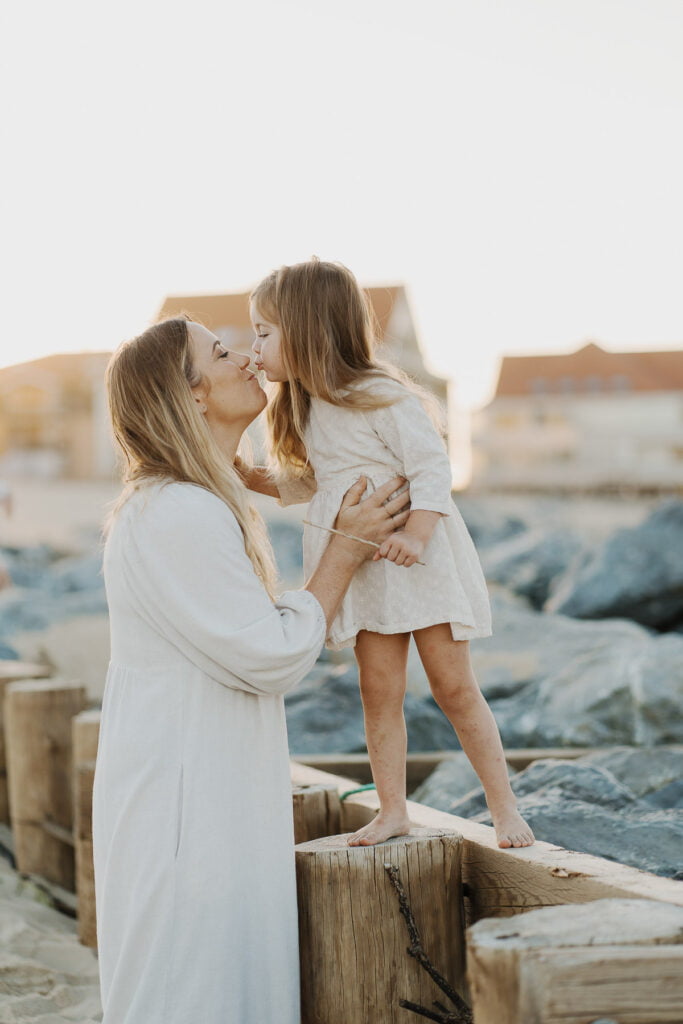 Une mère et sa fille se font un bisous sur la plage de moliets dans les Landes.