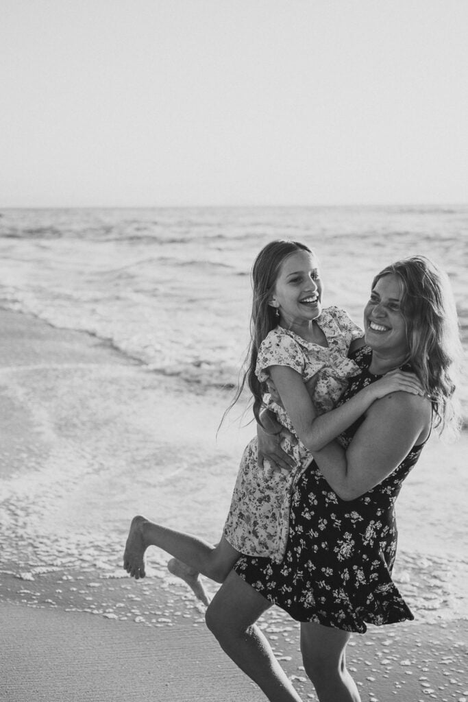 Une photo en noir et blanc d’une mère et de sa fille à la plage.