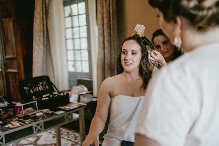 Une mariée se faisant coiffer dans une chambre, prête à être témoin de mariage.