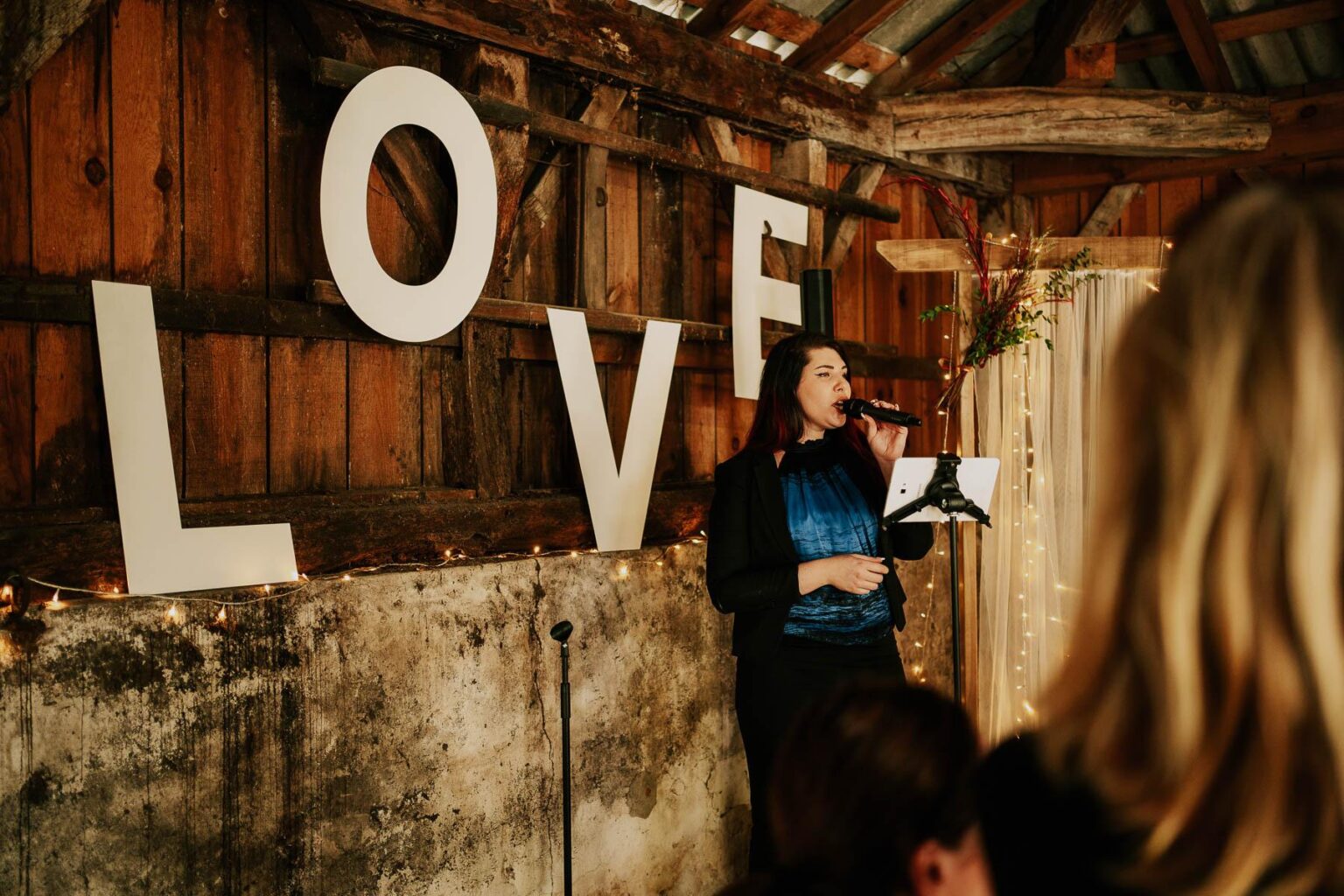 Une chanteuse se tient devant une pancarte qui dit amour.