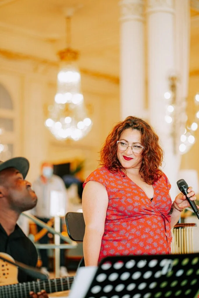 Une chanteuse chantant et jouant de la guitare acoustique lors d'un mariage.