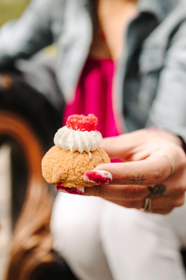 Une femme tenant une petite pâtisserie à la chantilly de Jeanne et Lulu.