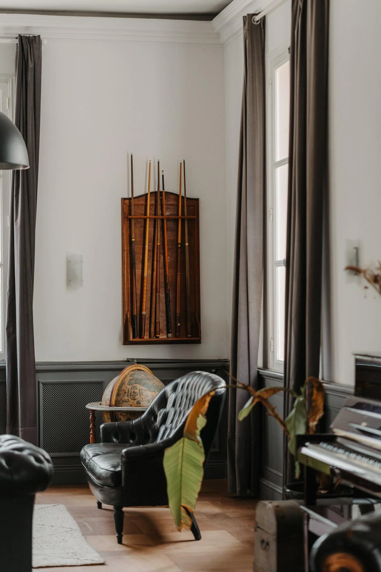Un salon avec des meubles noirs et un piano.