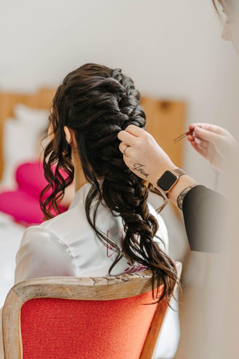 Une femme se fait coiffer par une coiffeuse dans une chambre d'hôtel pour son mariage dans les Landes.