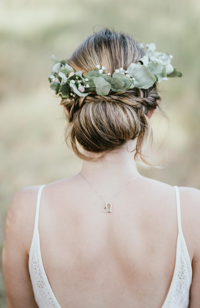 Le dos d'une mariée coiffée d'une couronne d'eucalyptus, préparé par une coiffeuse mariage landaise.