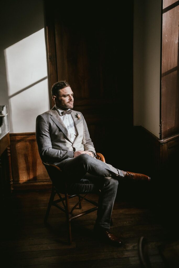 Un homme en costume assis sur une chaise.