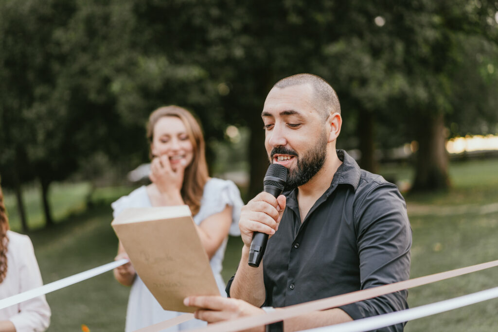 Un DJ tient un micro devant un groupe de personnes lors d'un mariage dans les Landes.