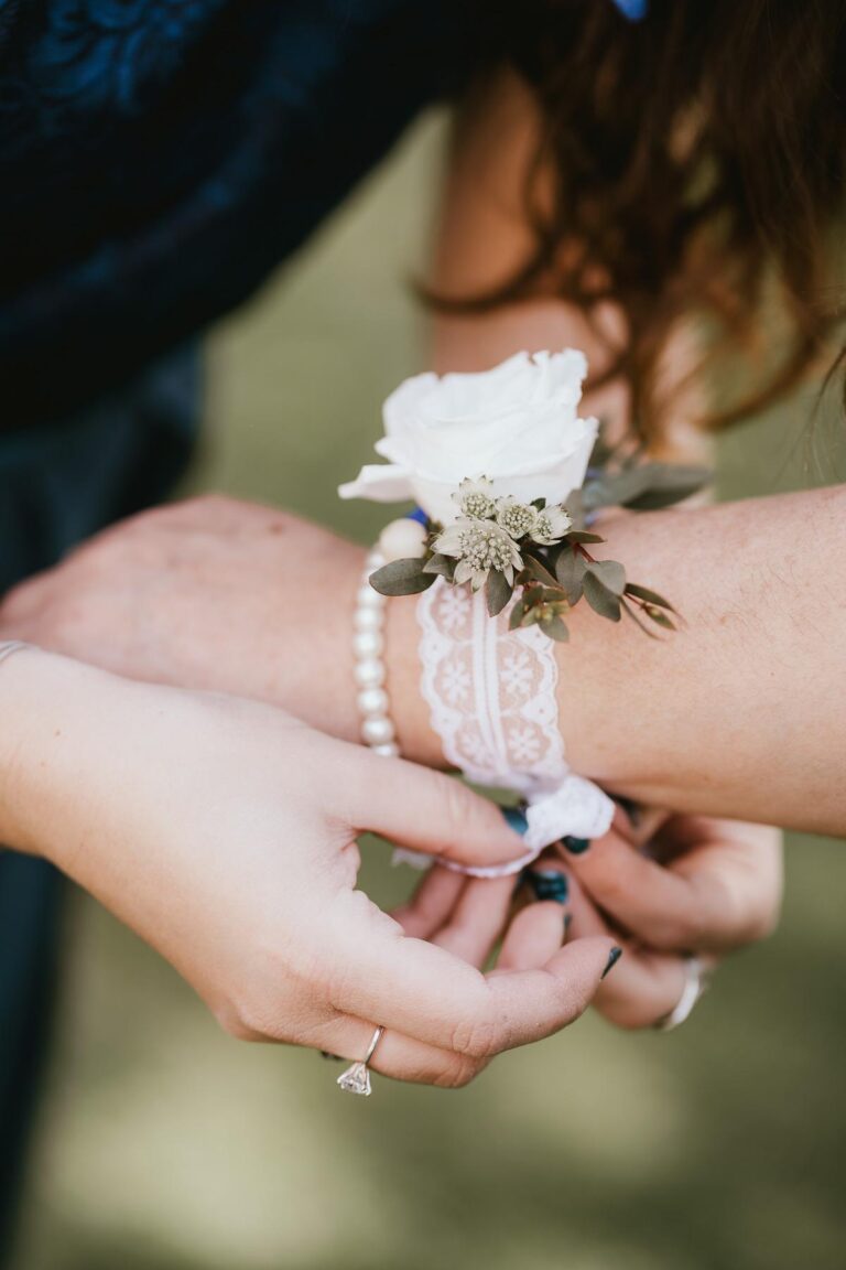 Une femme met une fleur de mariage fleuriste à son poignet.
