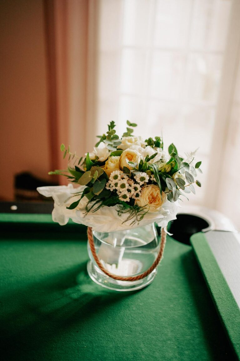Un bouquet de fleurs d'un mariage fleuriste Capbreton assis sur une table de billard.