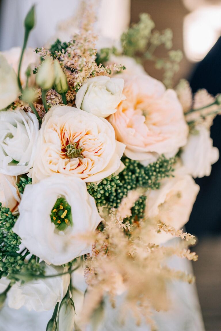 Un bouquet de fleurs blanches et pêche sur une table pour un mariage dans les Landes.