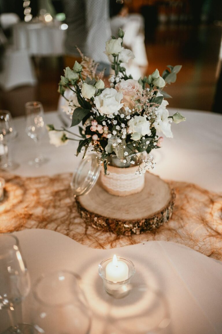 Une table en bois avec des bougies et des fleurs fleuristes.