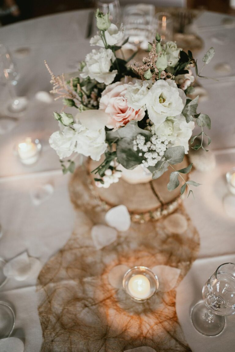 Une table avec des fleurs et des bougies, conçue par un fleuriste pour un mariage dans les Landes.