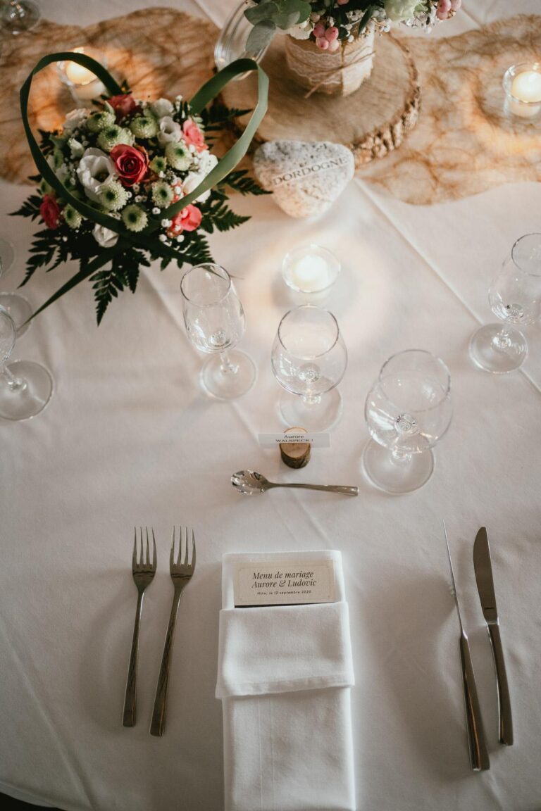 Une décoration de table avec des fleurs d'un fleuriste et de l'argenterie.