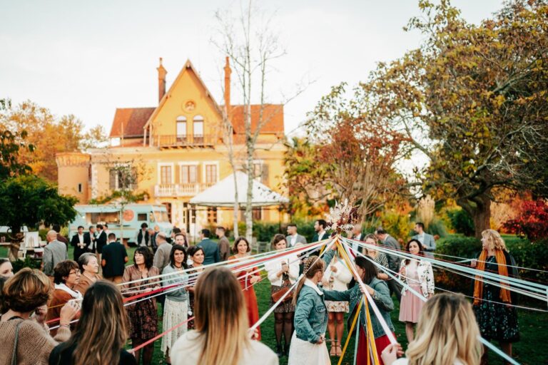 Un groupe de personnes s'est rassemblé autour d'une grande maison, attirés par l'odeur d'un food truck landais garé à proximité.