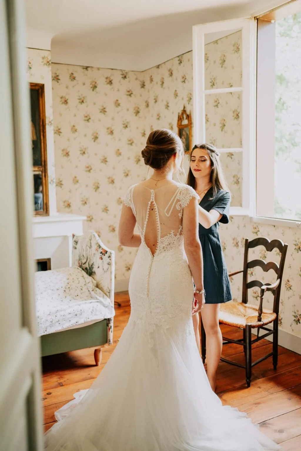 Une mariée se prépare dans une pièce avec une fenêtre.
