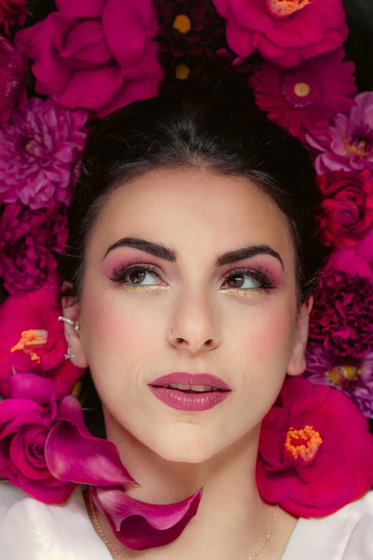 Une femme posant devant un bouquet de fleurs, habillée par une maquilleuse de mariage landais.