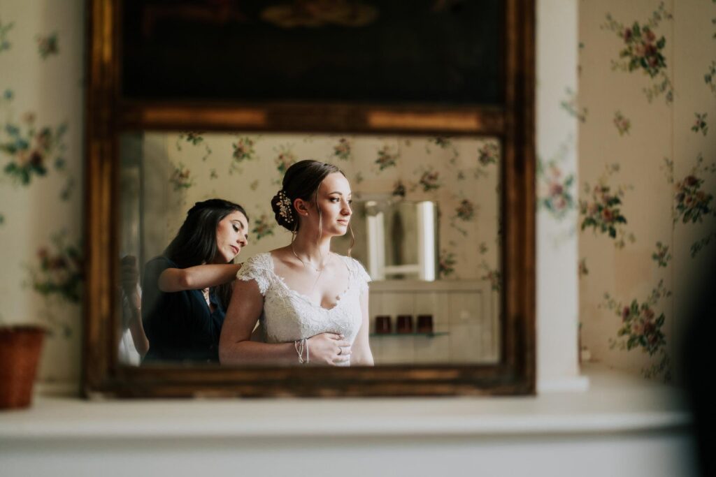 Une mariée se prépare devant un miroir, vêtue de sa « robe de mariage landaise ».